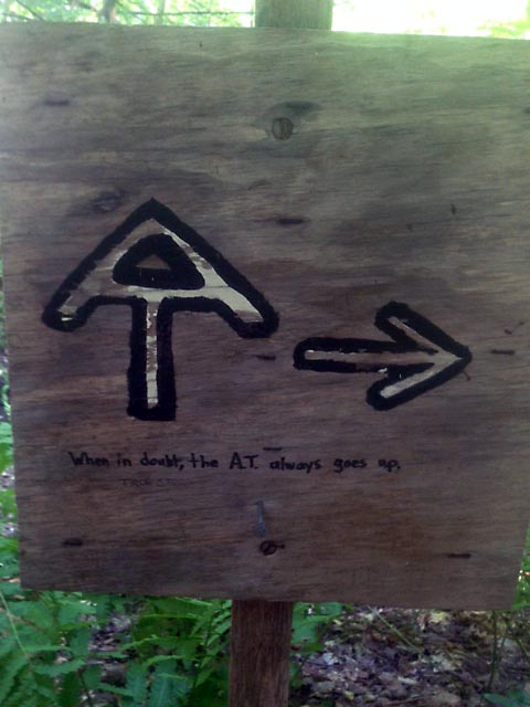 A sign on the trail indicating a turn, with the accurate graffiti, "When in doubt, the A.T. always goes up."
